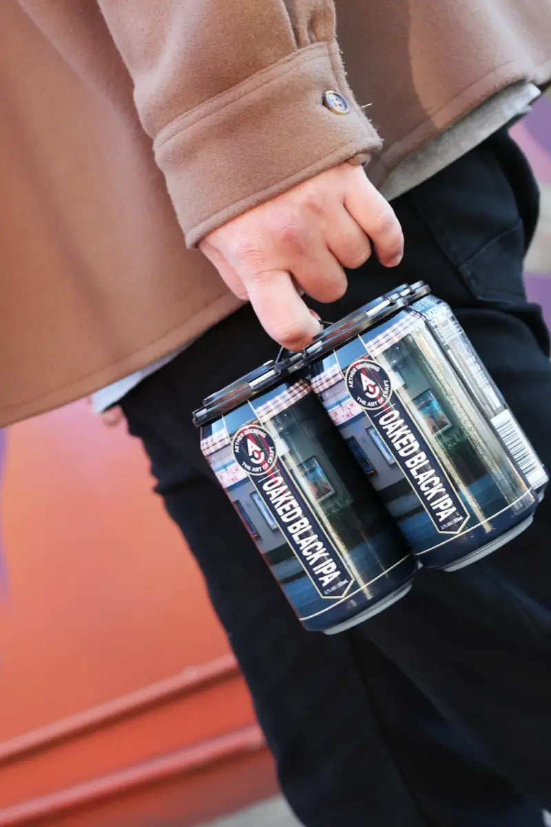 Brisbane craft beer by Aether Brewing – a 4-pack being carried home after buying online. Oaked Black IPA poured dark with a creamy head. Limited release, all-natural Australian beer.
